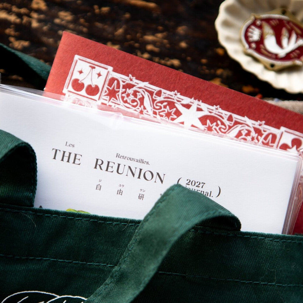 The Reunion journal in its card-pocket cover, tucked into a green tote. Photo: OURS Studio
