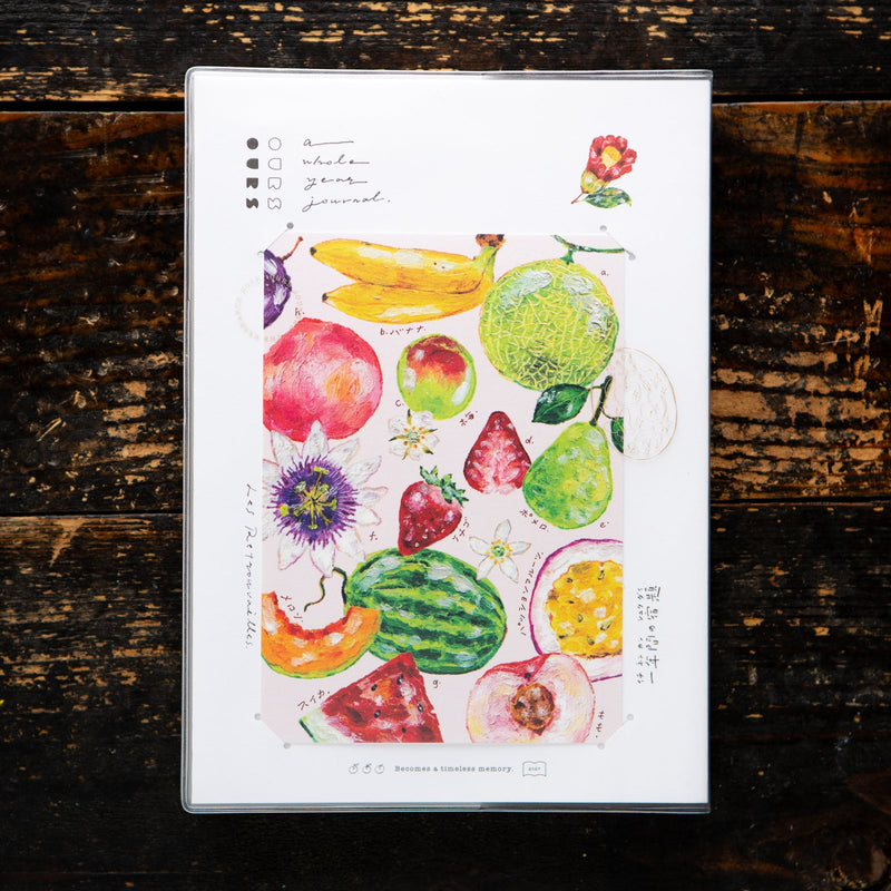 OURS Studio 2027 journal, The Reunion, with the painted fruit postcard in its cover slot. Photo: OURS Studio